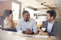 Three Businessmen Meeting In Coffee Shop Shot Through Window Royalty Free Stock Photo