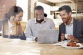 Three Businessmen Meeting In Coffee Shop Shot Through Window