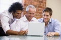 Three businessmen sitting in office with laptop