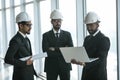 Three businessmen in ties and hardhats surprised with window scene. Property investor visiting site and impressed with neighboring