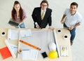 Three businesspeople, female secretary, a boss in formal suit and male engineer standing together in office and discussing Royalty Free Stock Photo