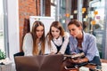 Three businesswomen discussing their business project using laptop together in office