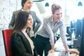 Three businesswomen working together at office desk having meeting and discussing a project from computer monitor Royalty Free Stock Photo