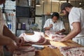 Three butchers preparing meat,cuts of meat to sell at a butcher'