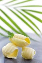 Three Butter curl or roll, front view.greenery in the background Royalty Free Stock Photo