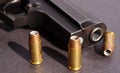 Three hollow point bullets next to a black pistol Royalty Free Stock Photo