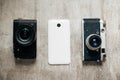 Three camera retro and modern mobile phone on a light gray background