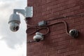 Three Security Cameras Mounted on a Red Brick Wall Royalty Free Stock Photo