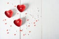 Three candles in the form of red heartbeats on a white background and scattered confetti