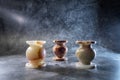 three candlesticks made of onyx on a gray background