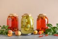 Three canned apple and cherry compote in large glass jars on gray table.