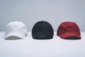 Three caps in white, black, and red on plain white background Royalty Free Stock Photo