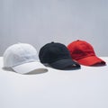Three caps in white, black, and red on plain white background Royalty Free Stock Photo