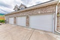 Three car garage doors exterior with bricks and lamps Royalty Free Stock Photo