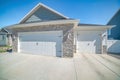 Three-car side hinged garage doors with stone veneer wall siding Royalty Free Stock Photo