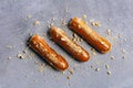 Three caramel eclairs on a grey counter