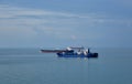 Three cargo ships are sailing through the cam, blue sea. Royalty Free Stock Photo