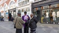 Three Caribbean people standing in the middle of the road and chatting. Mayfair, London