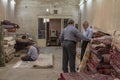 Three carpet sellers discussing and praying in a rug shop in the Yazd Khan bazaar. Carpets are of the main iconic exports of Iran