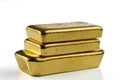 Three cast gold bars are in a pile. Isolated on a white background Royalty Free Stock Photo