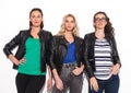 Three casual women in leather jackets looking up