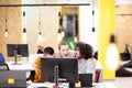 Three caucasian colleagues cheering for job well done in a modern office with decorative hanging lightbulbs