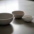 Three ceramic bowls of varying sizes each containing small white beads are Royalty Free Stock Photo