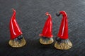 Ceramic Christmas elves in red hats on a black background Royalty Free Stock Photo