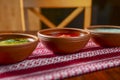 Three ceramic plates with different soup on a table. Borsch - beetroot soup, chicken broth and cold soup okroshka Royalty Free Stock Photo