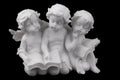 Three ceramic white angels read the book, dreaming and thinking. Royalty Free Stock Photo