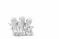 Three ceramic white angels read the book, dreaming and thinking. Royalty Free Stock Photo