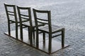 Three chairs at the cobbled square, modern bench in the city