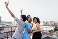 Three charming African American girls and mixed race guy are dancing on roof