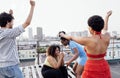 Three charming African American girls and mixed race guy are dancing on roof