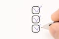 three checkboxes. hand with pen writing check mark on Checklist. Cropped Hand Marking On Check Box on white paper. Completed tasks Royalty Free Stock Photo