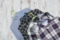 Three checkered shirts on wooden background. Fashionable concept