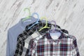 Three checkered shirts on wooden background. Fashionable concept