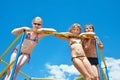 Three cheerful children on the bar at playground