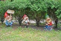 Three cheerful dwarves. Garden sculpture in the park