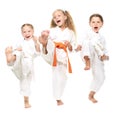 Three cheerful girl dressed in a white kimono kick leg Royalty Free Stock Photo