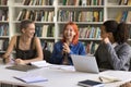 Three cheerful schoolmates share creative ideas working on joint task