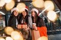 Three cheerful women spends Christmas holidays together outdoors. Conception of new year Royalty Free Stock Photo