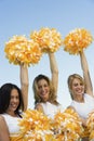 Three Cheerleaders rising pom-poms