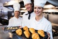 Three chefs holding a tray of baked croissant and cookies Royalty Free Stock Photo