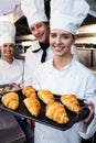 Three chefs holding a tray of baked croissant and cookies Royalty Free Stock Photo