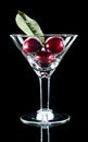 Three cherry and leaf in wine glass Royalty Free Stock Photo