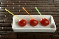 Three cherry tomatoes with color sticks Royalty Free Stock Photo