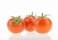 Three cherry tomatoes with reflections, on white Royalty Free Stock Photo