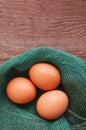 Three chicken brown eggs in a nest of green color from fabric Royalty Free Stock Photo
