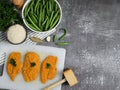 Three chicken chops on a white board.